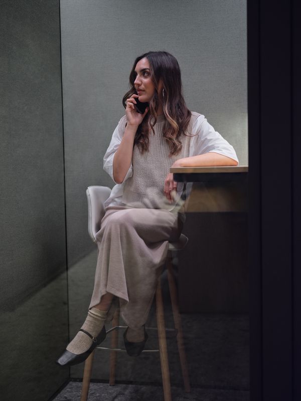 Internship candidate taking their first steps into a premium beauty and fashion career, working on a laptop in a modern office environment