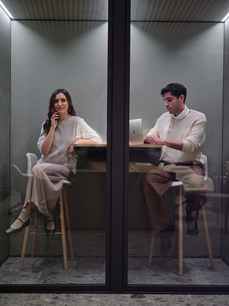 man and woman working with a mobile phone and a computer